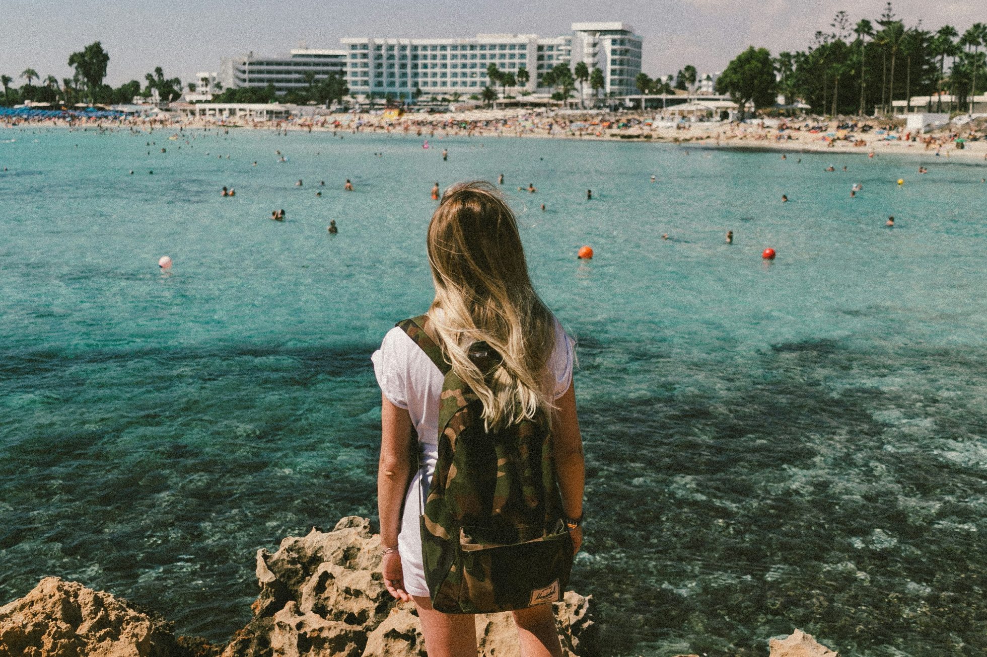Piękna plaża z błękitnym morzem i jasnym piaskiem. Palmi, leżaki i parasole nadają miejscu relaksujący klimat.