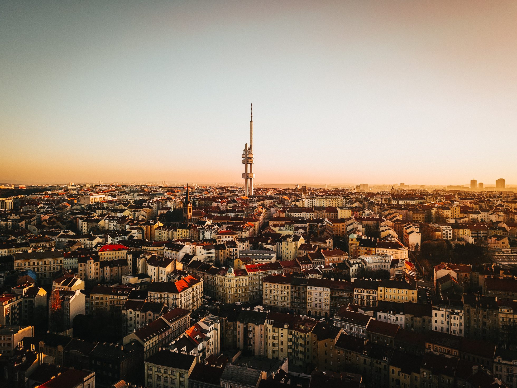 Panoramiczny widok na budynki Pragi i wieżę Zizkov po zachodzie słońca