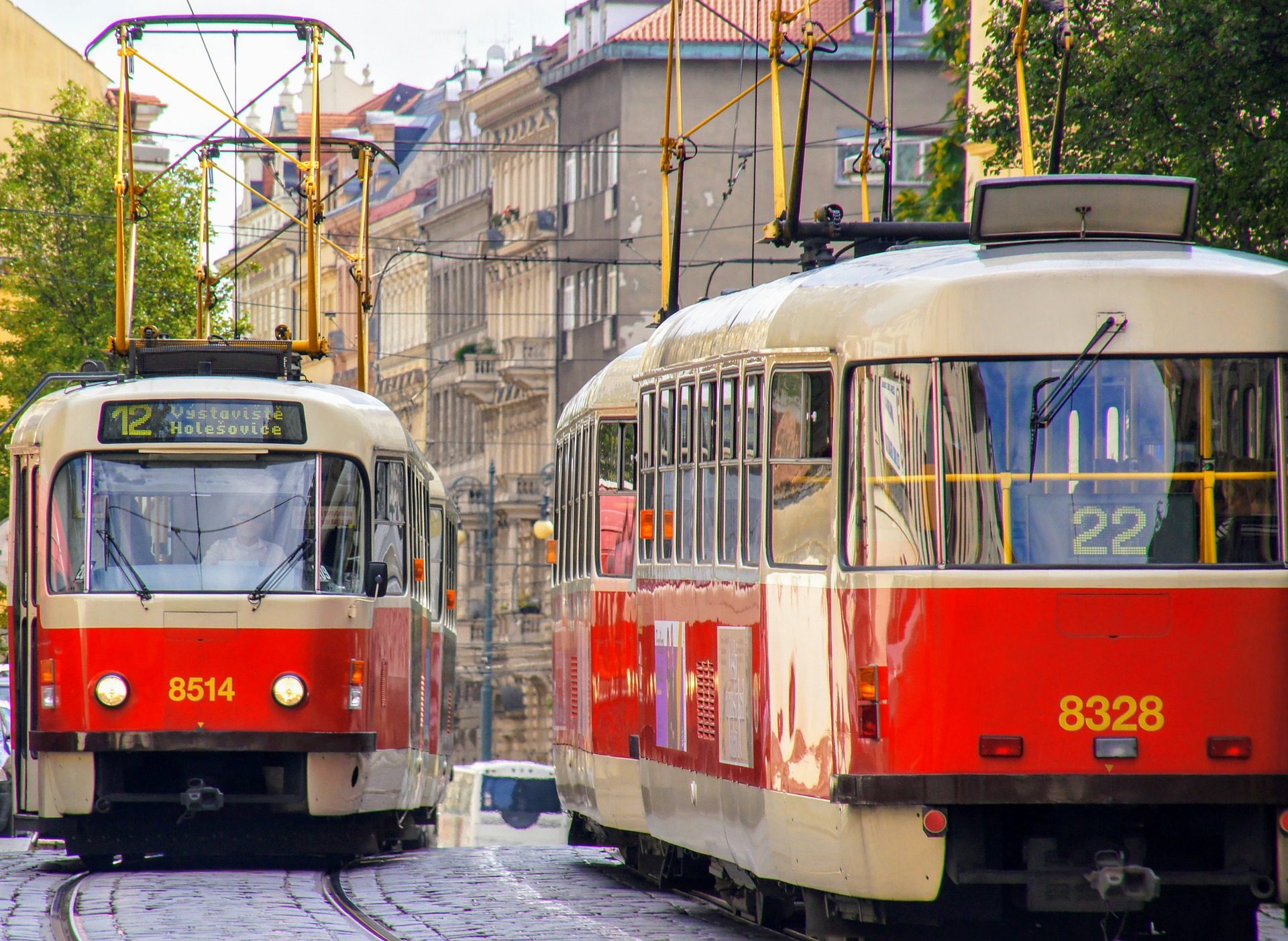 Czerwone tramwaje jeżdżące po ulicy Pragi