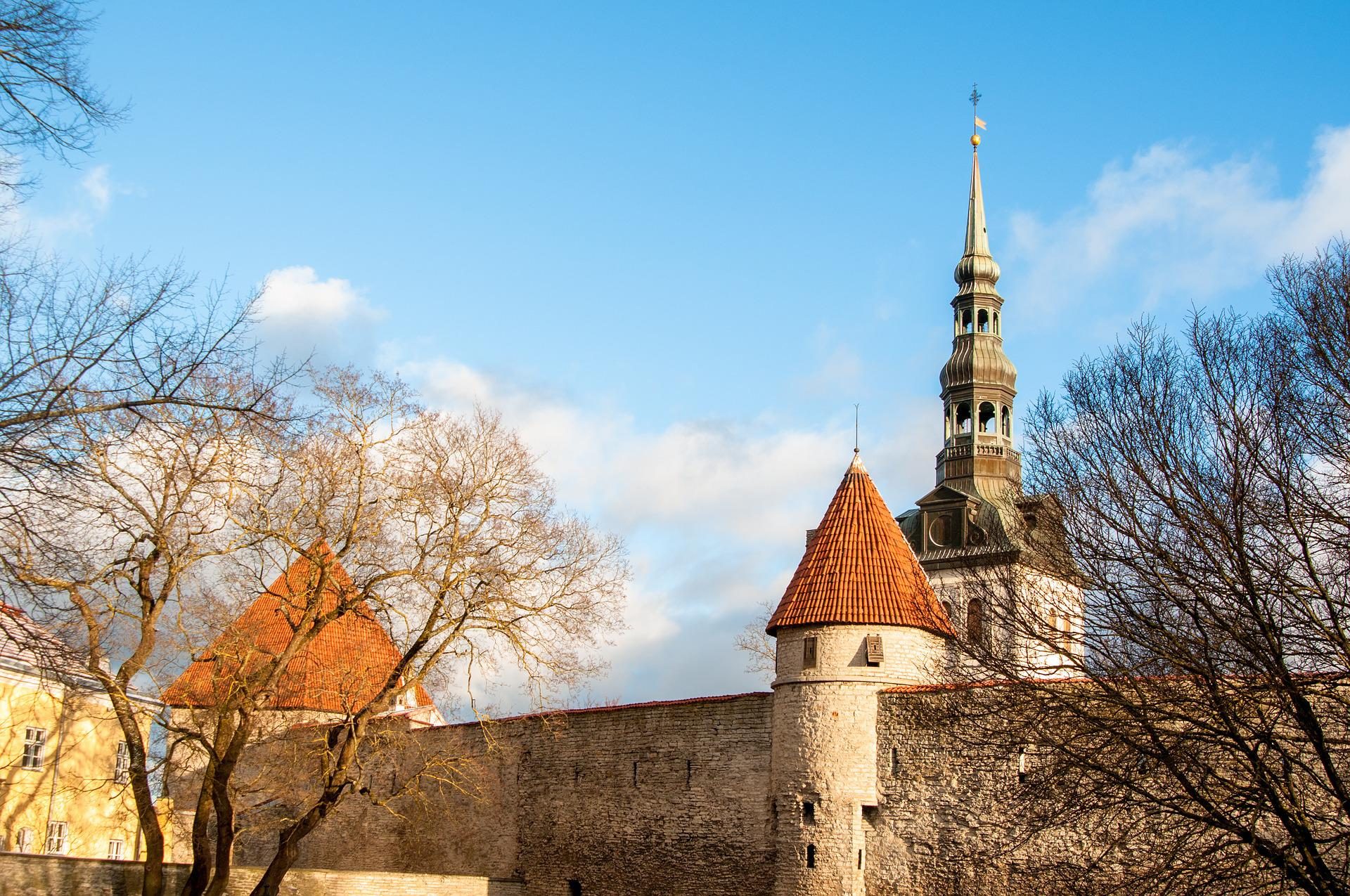 Zabytkowe mury miejskie, a w tle wieża kościoła św. Mikołaja... to właśnie Tallinn!