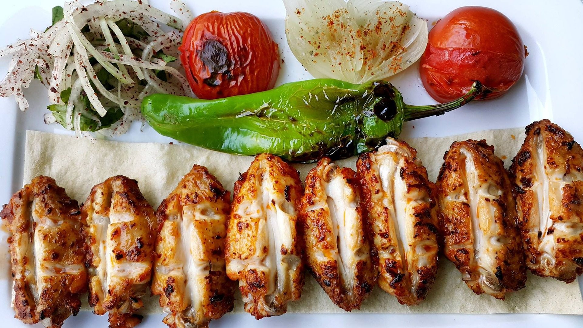 Turecki kebab podany na talerzu z grillowanymi warzywami