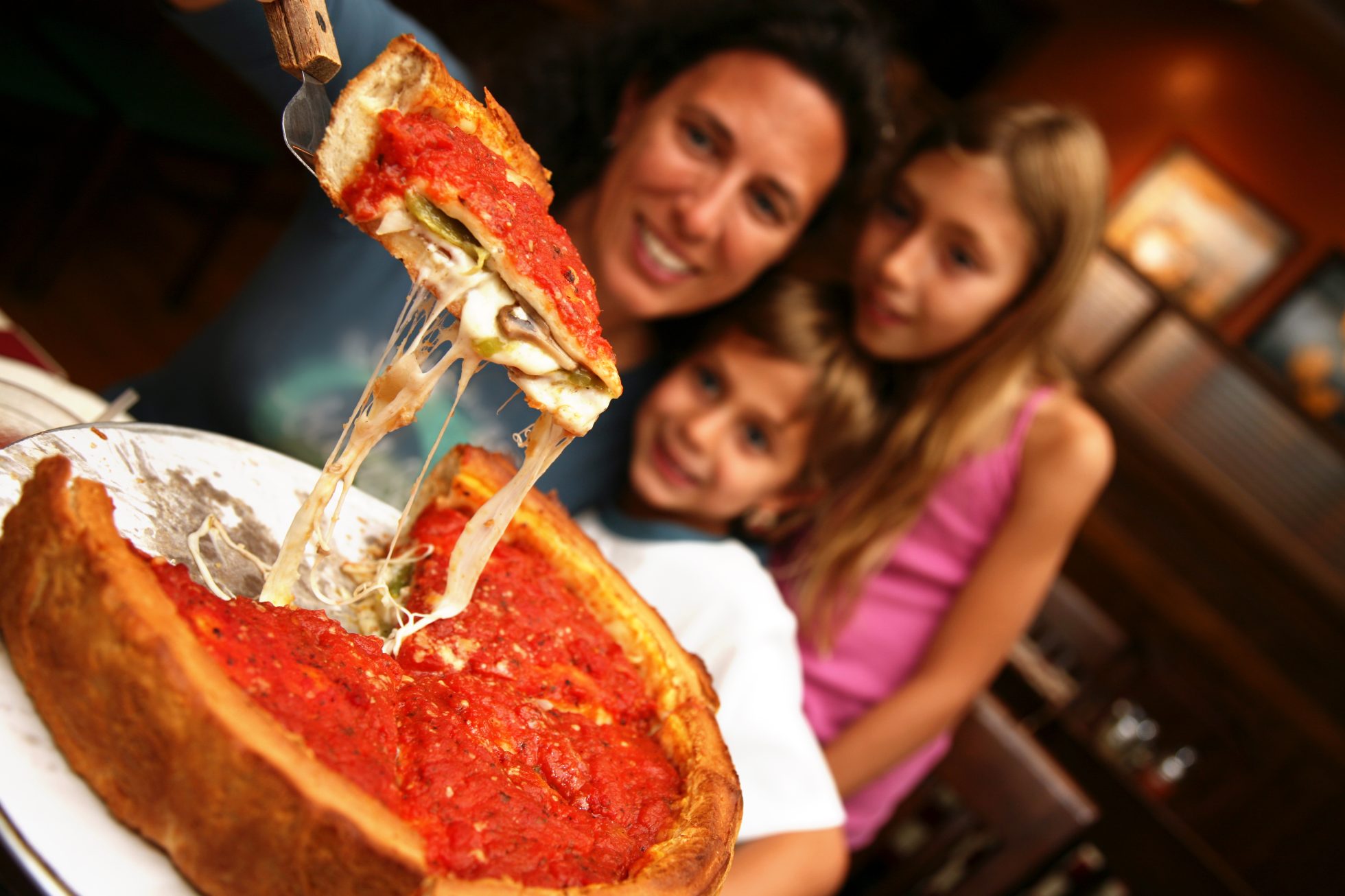 Lovely family enjoying Chicago-style deep pizza.