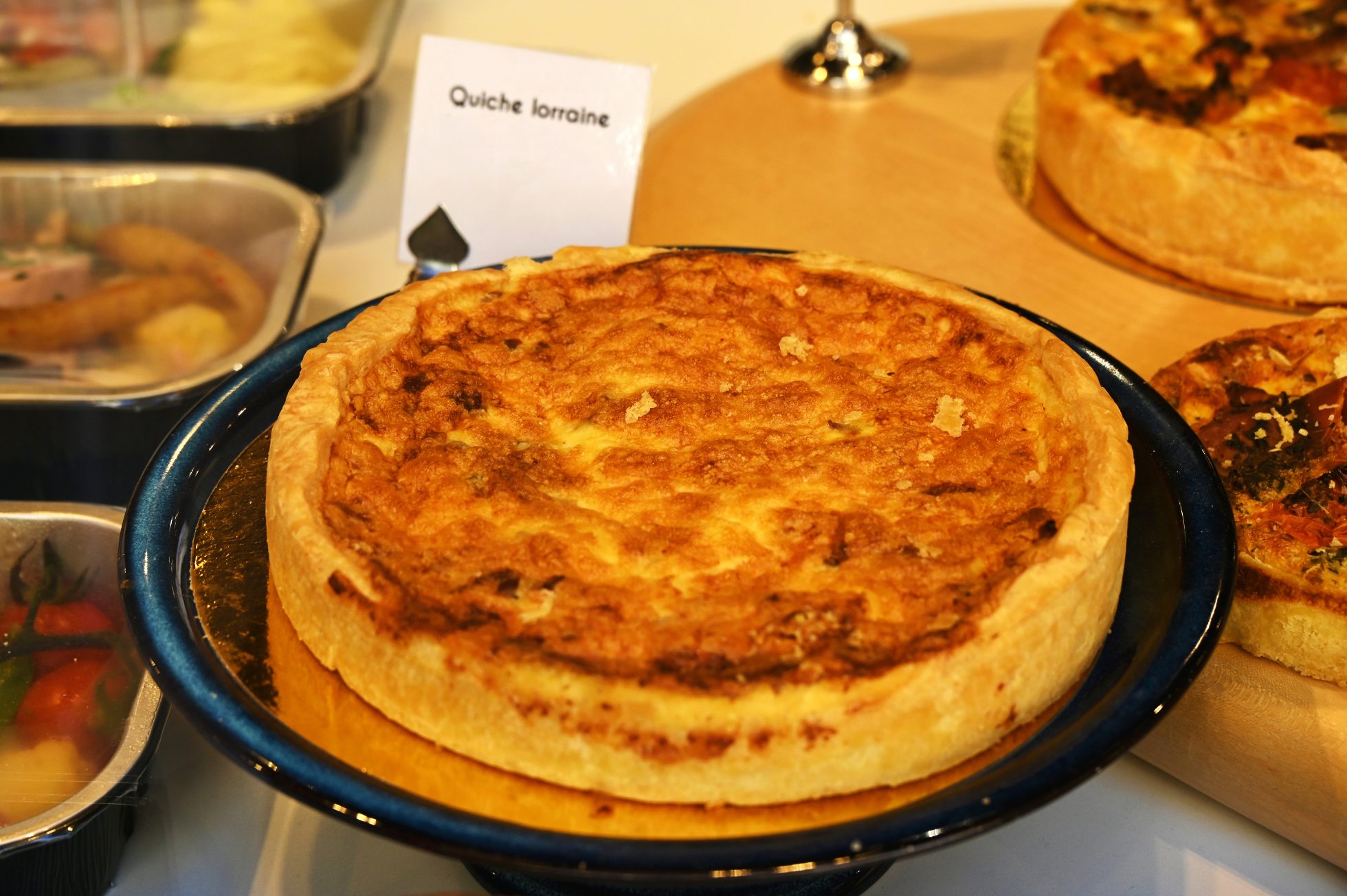 Pyszne quiche lorraine na złotej tacy.