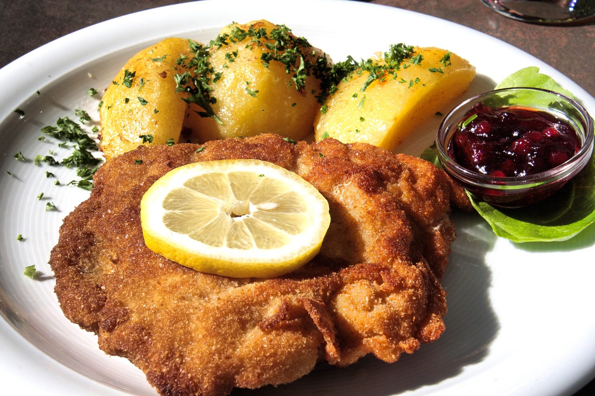 Typowy austriacki obiad ze sznyclem wiedeńskim i pieczonymi ziemniakami, kuchnia austriacka