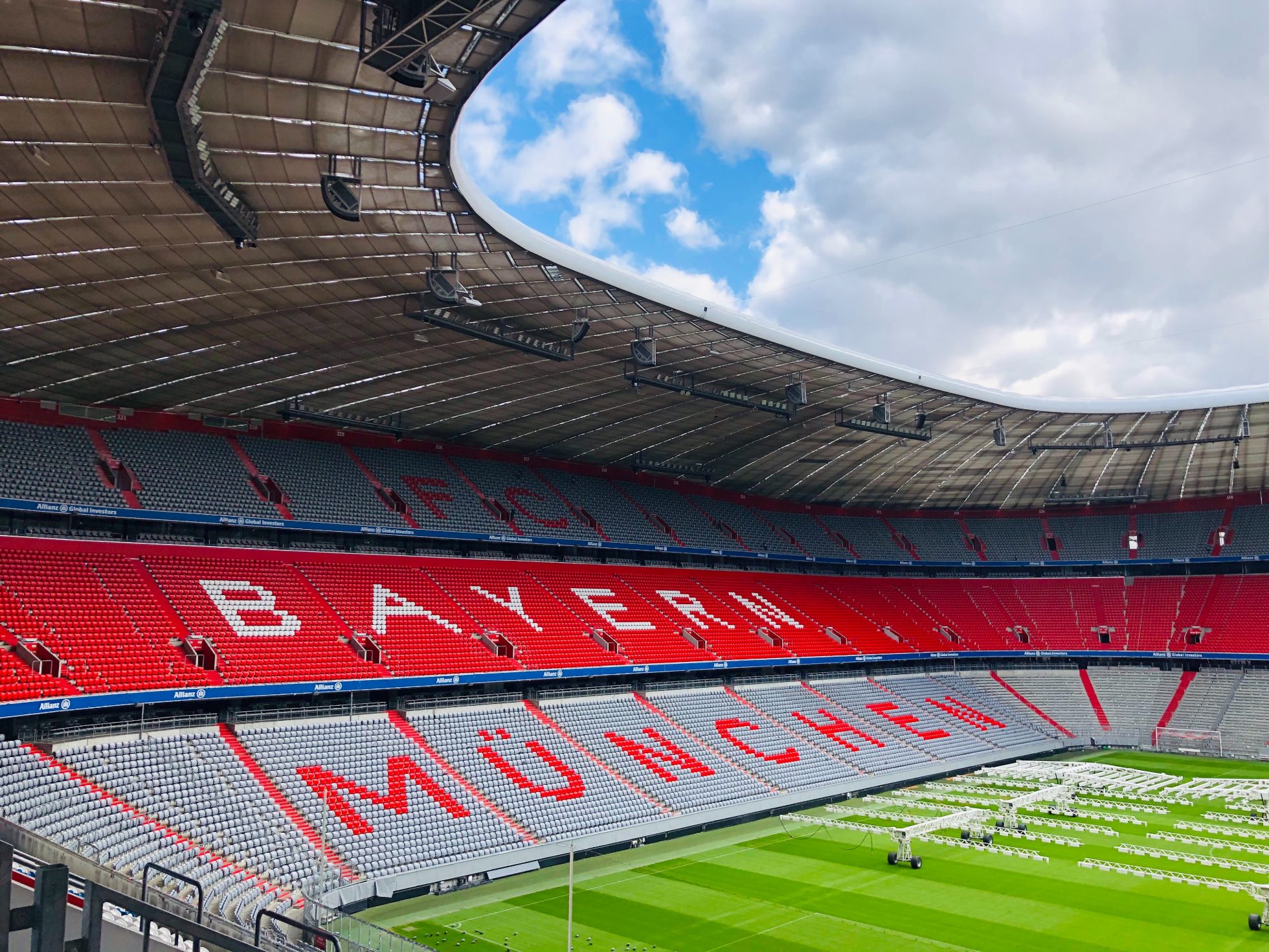 Wnętrze stadionu Bayern Monachium z trybunami z nazwą i w kolorach klubu.