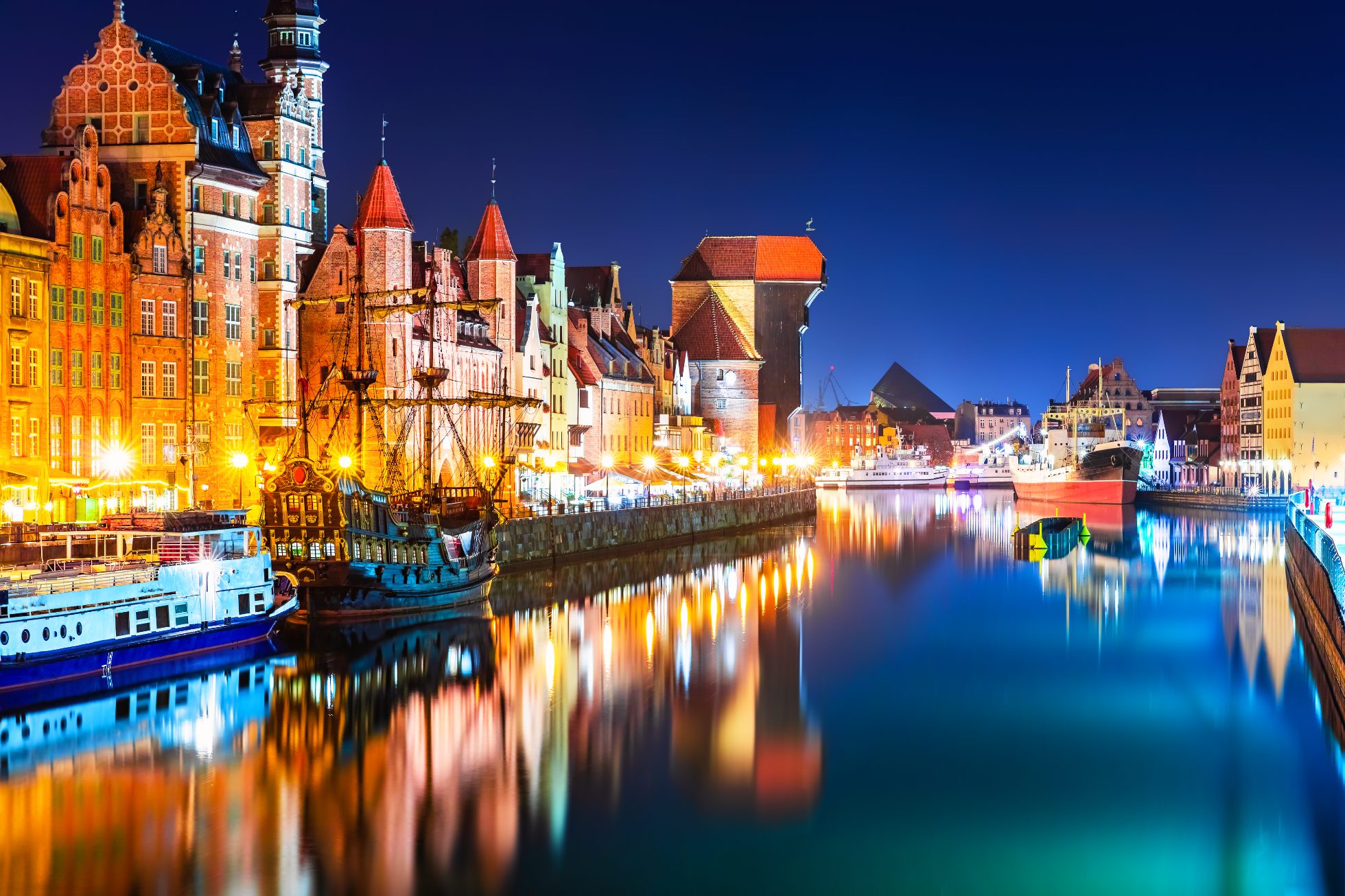 Nocny widok z kładki na architekturę Starego Miasta w Gdańsku przy rzece Motława.