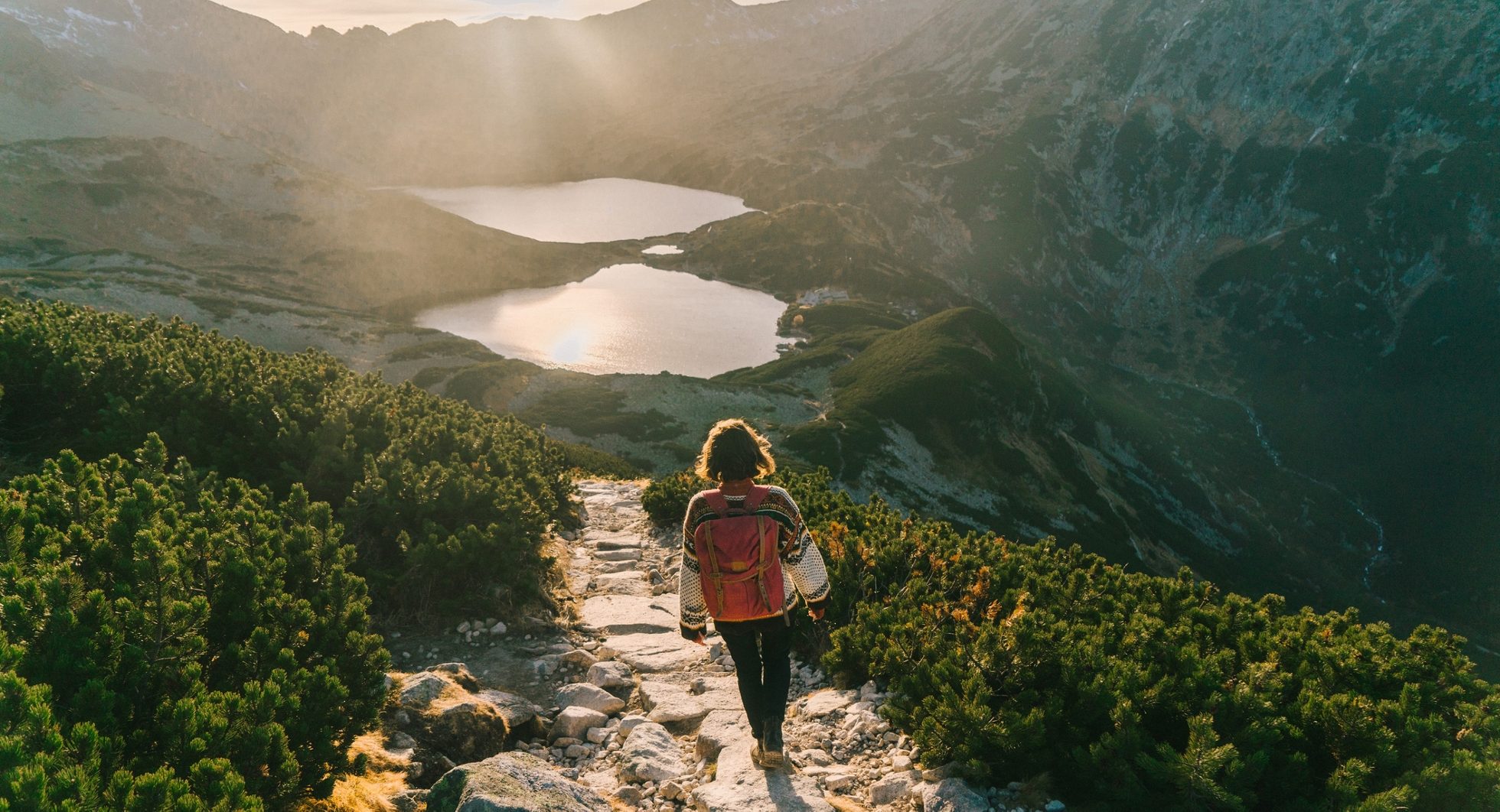 A woman descending in the setting sun towards Morskie Oko in the Tatra Mountains.