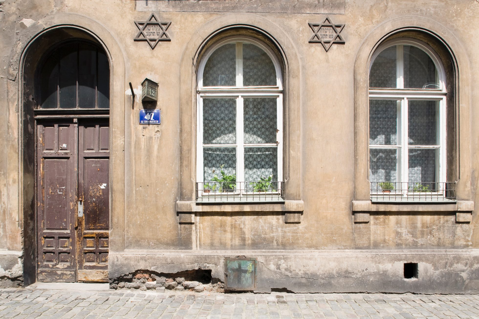Zdjęcie przedstawia zabytkowy Kraków z lotu ptaka. Widoczne są kamienice, rynek oraz zielone tereny wokół miasta.