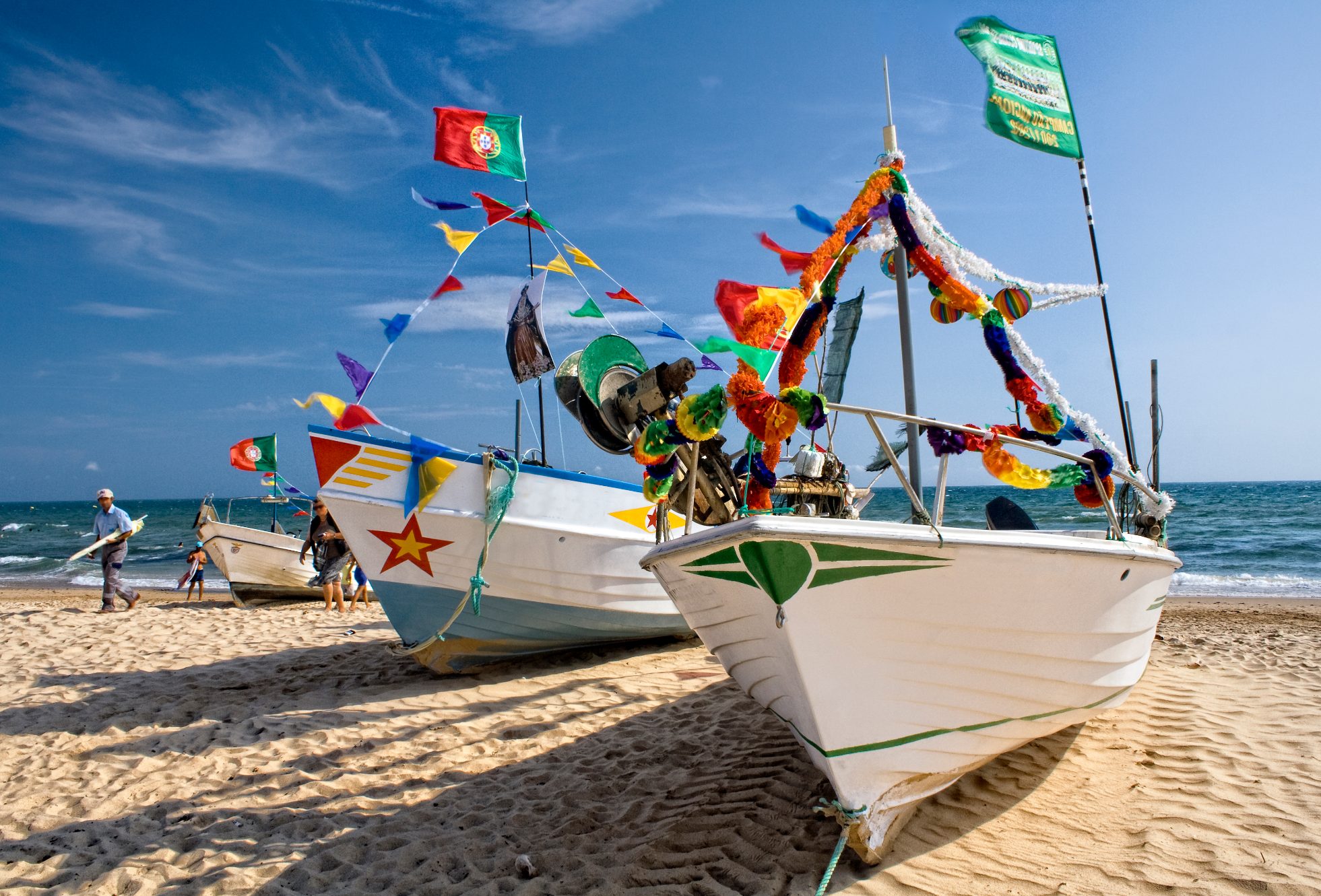 Przystrojone na kolorowo łodzie rybackie na plaży w Algavre