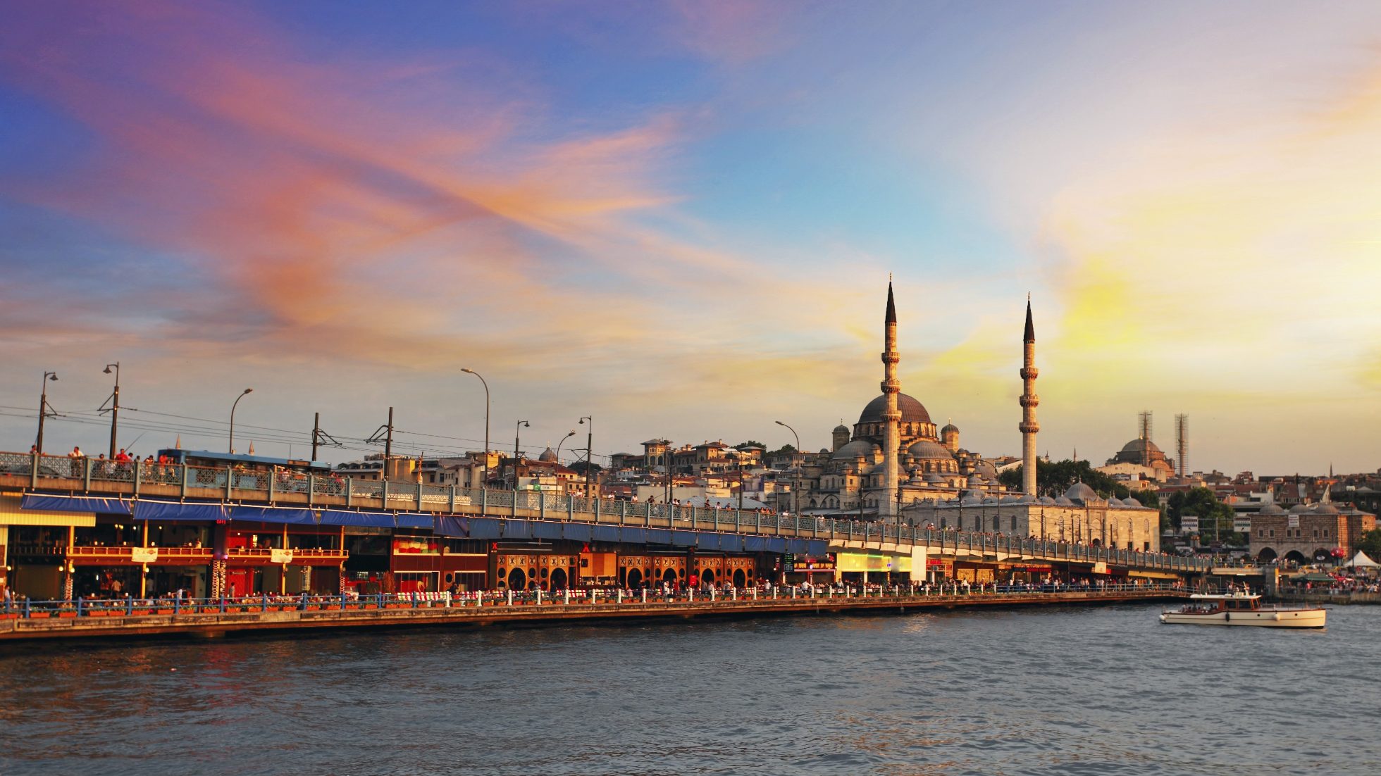 A view of the Golden Horn Bay towards the Galata Bridge and the New Mosque in Istanbul, Turkey, at sunset.