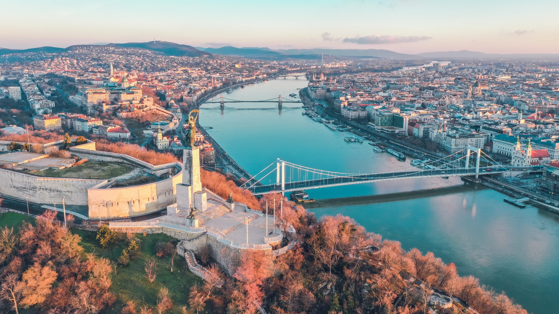 Widok na zabytkowy budynek w Budapeszcie przy brzegu rzeki.