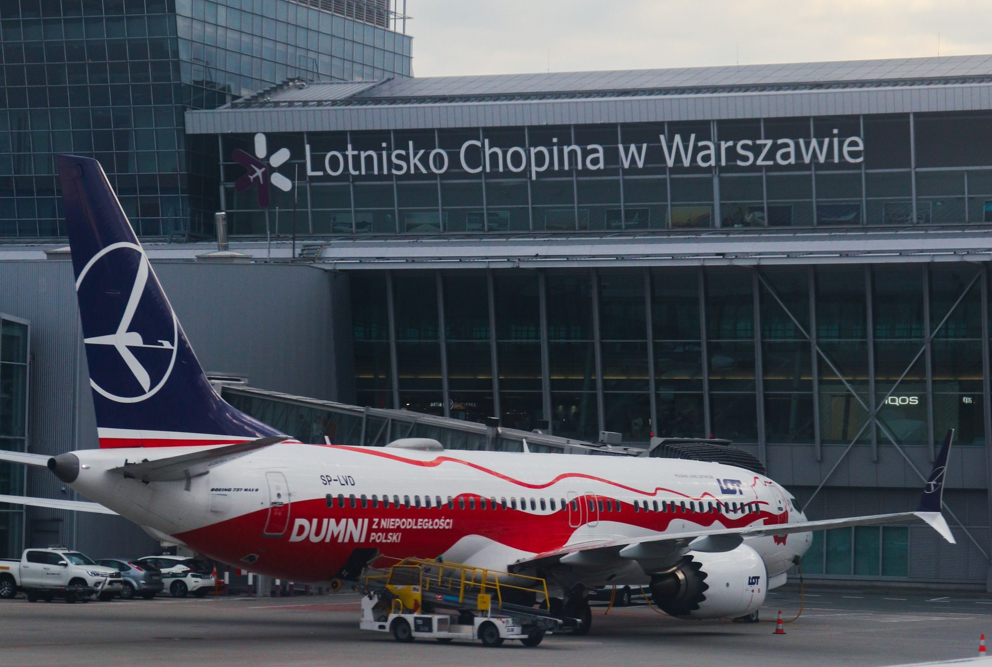 Widok na terminal Lotniska Chopina i stojący pod gate samolot LOT-u