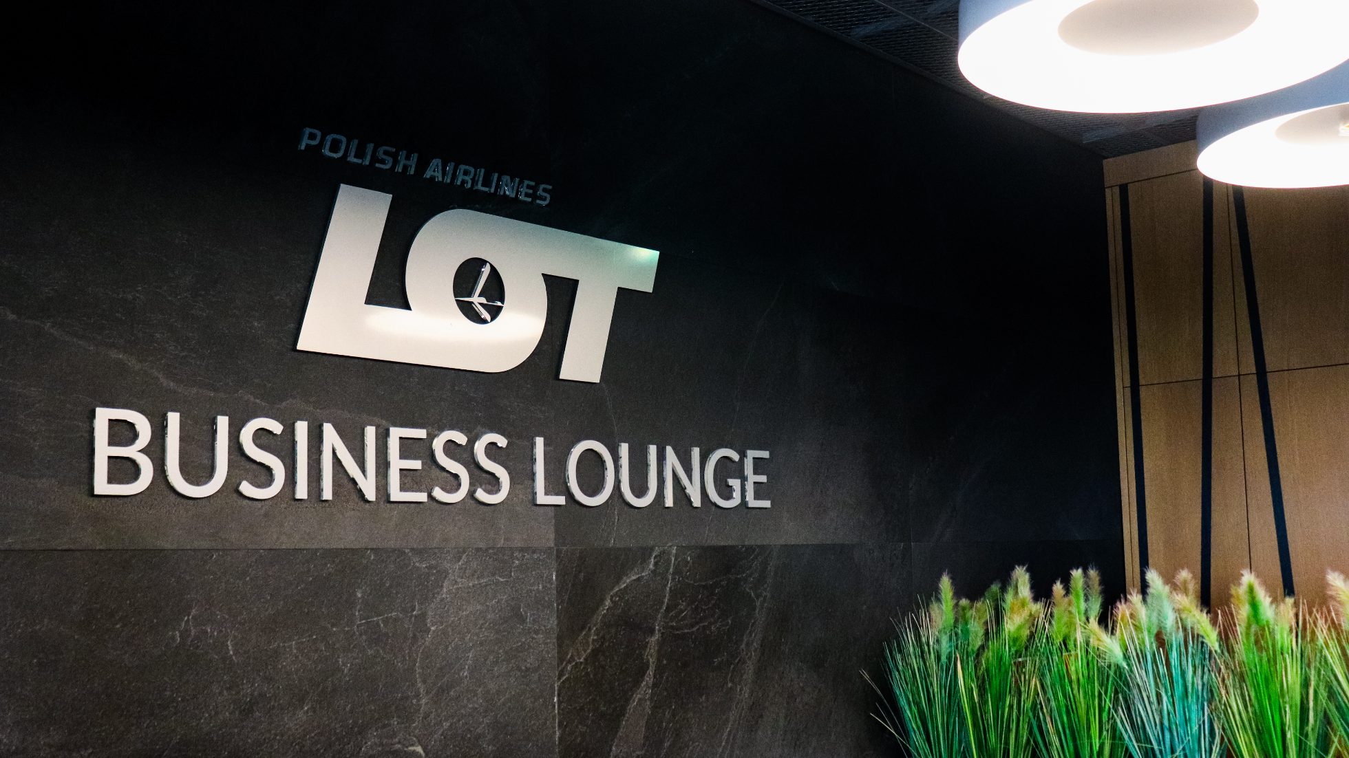 Srebrny znak "LOT Business Lounge" na ścianie