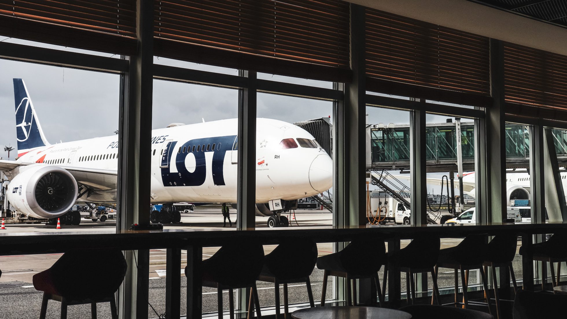 LOT Business Lounge Mazurek - panoramiczne okna z widokiem na stojący na płycie Boeing 787 Dreamliner.