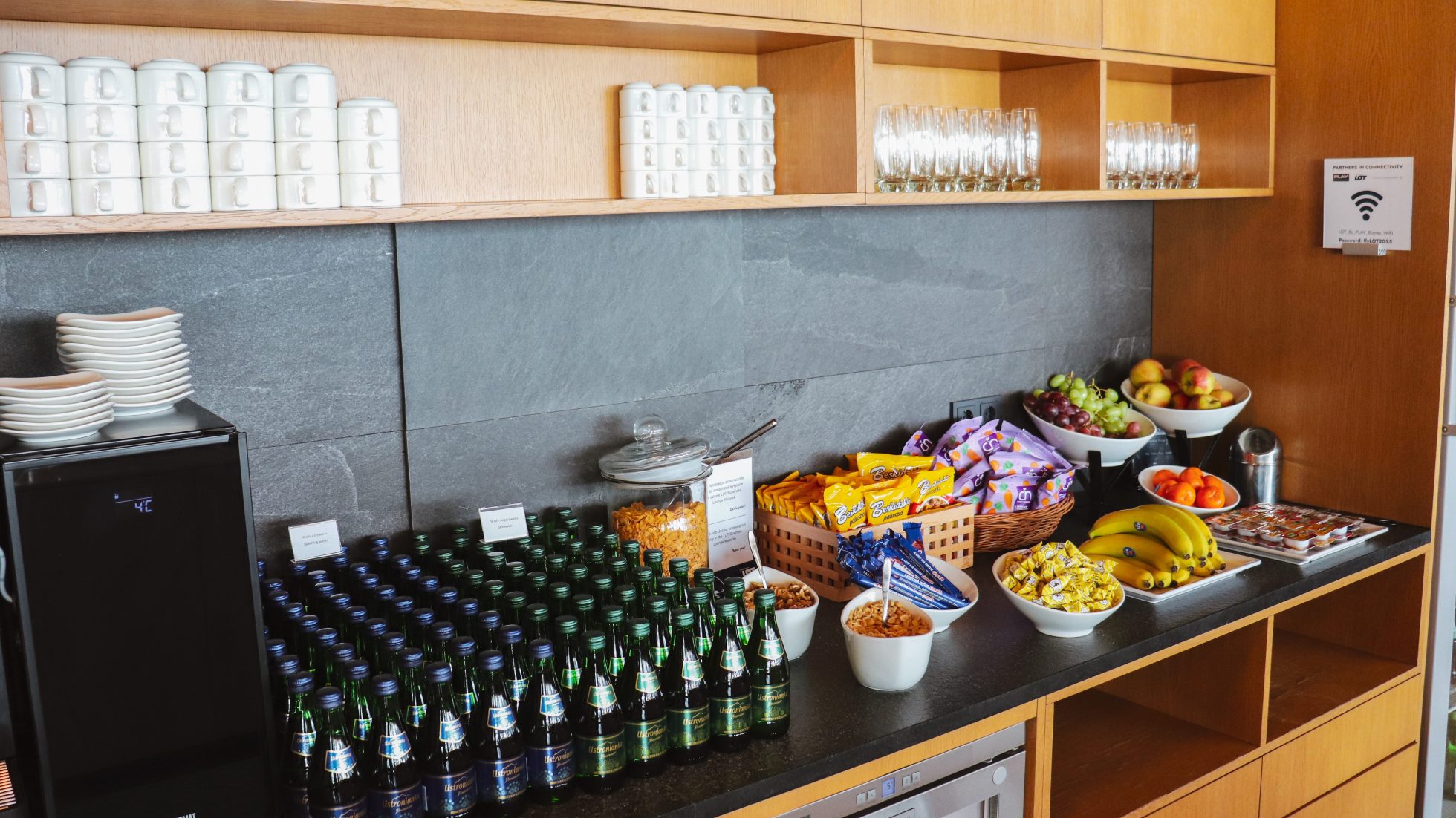 Szklane butelki wody i przekąski dla gości LOT Business Lounge Mazurek