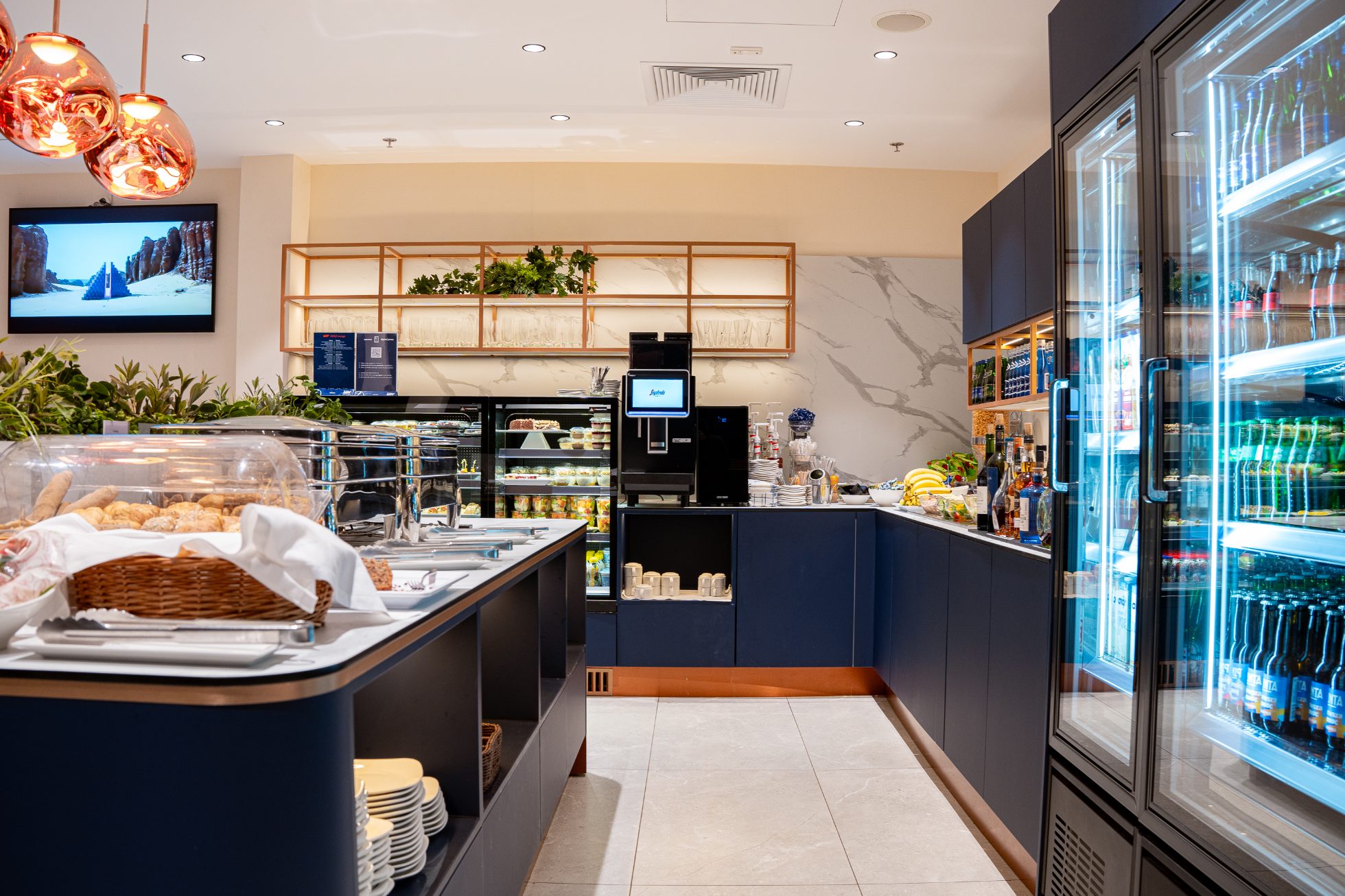 Przestrzeń restauracyjna, stół z posiłkami, lodówki z przekąskami dla Gości Polonez Gold Lounge