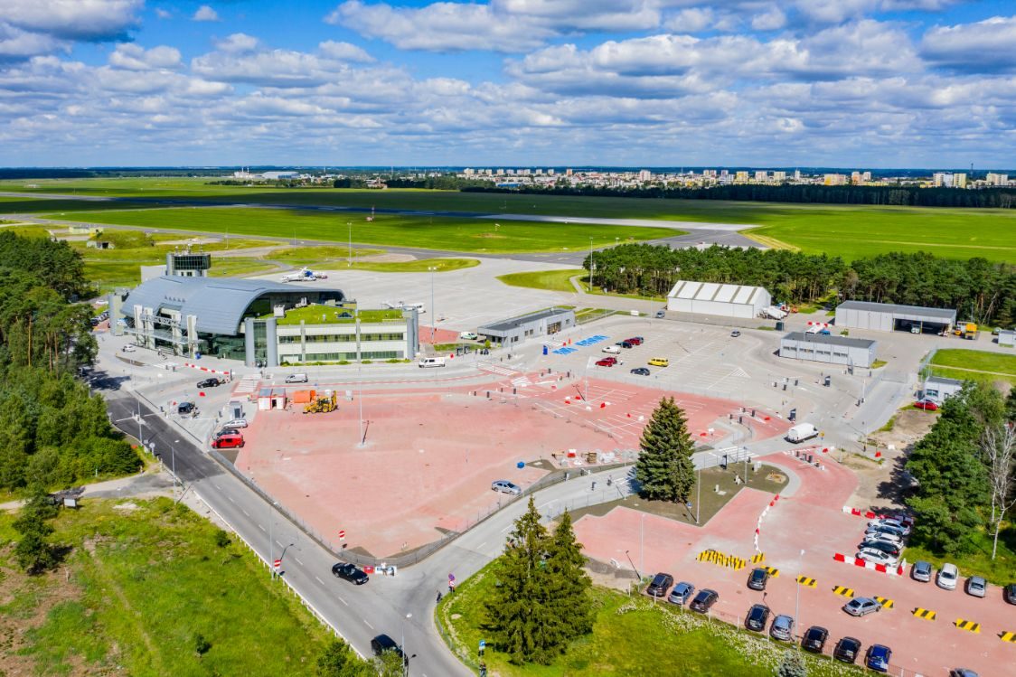Lotnisko w Bydgoszczy z lotu ptaka (czerwony parking i dużo zieleni wokół)