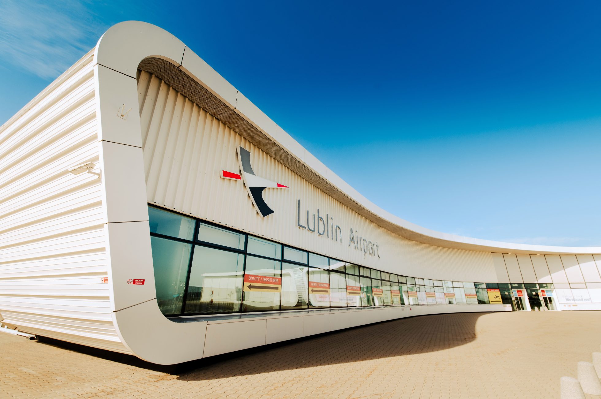Zdjęcie lotniska w Lublinie. Na zdjęciu biała ściana z nazwą Lublin Airport