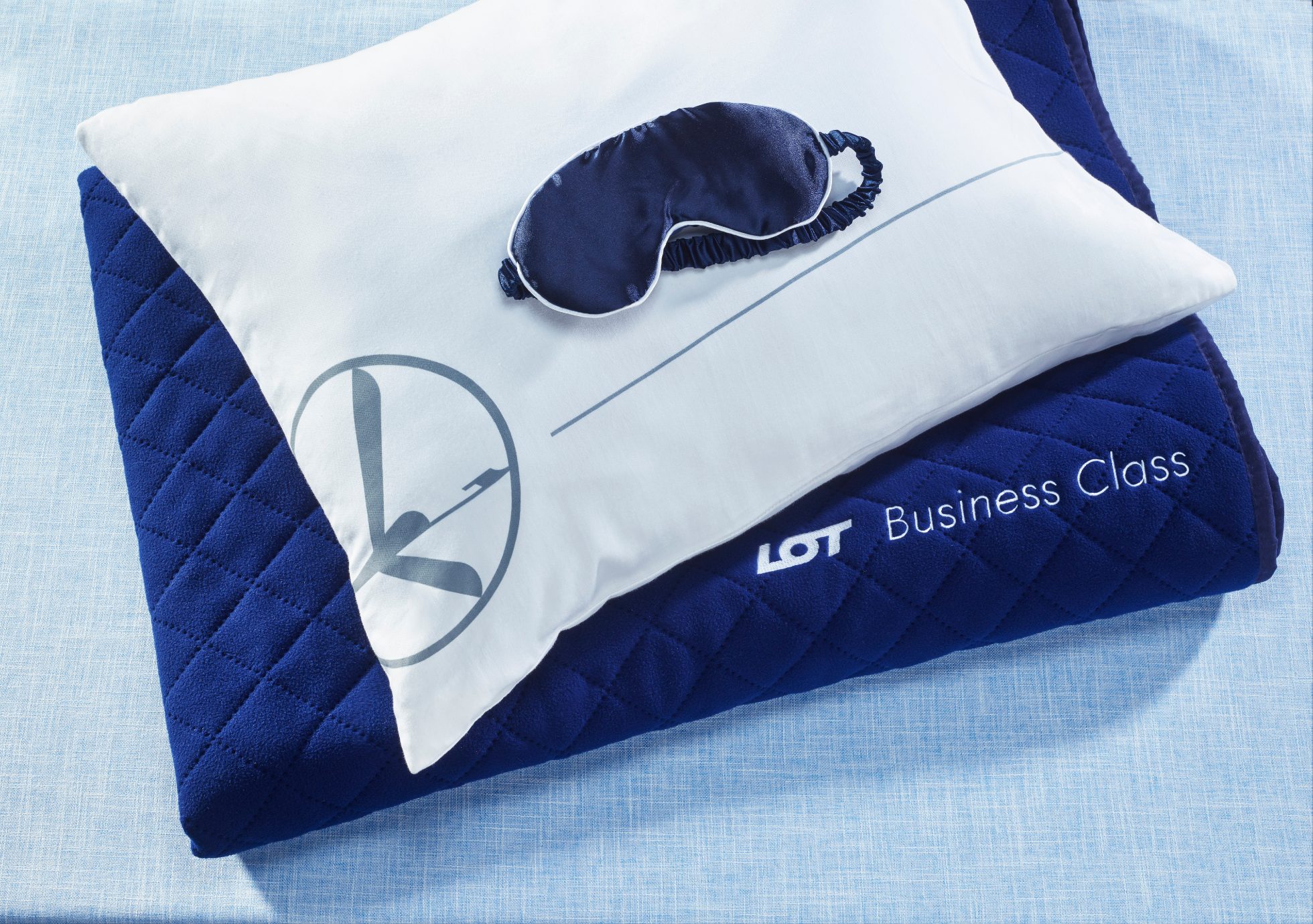 LOT travel pillow and blanket on white background.