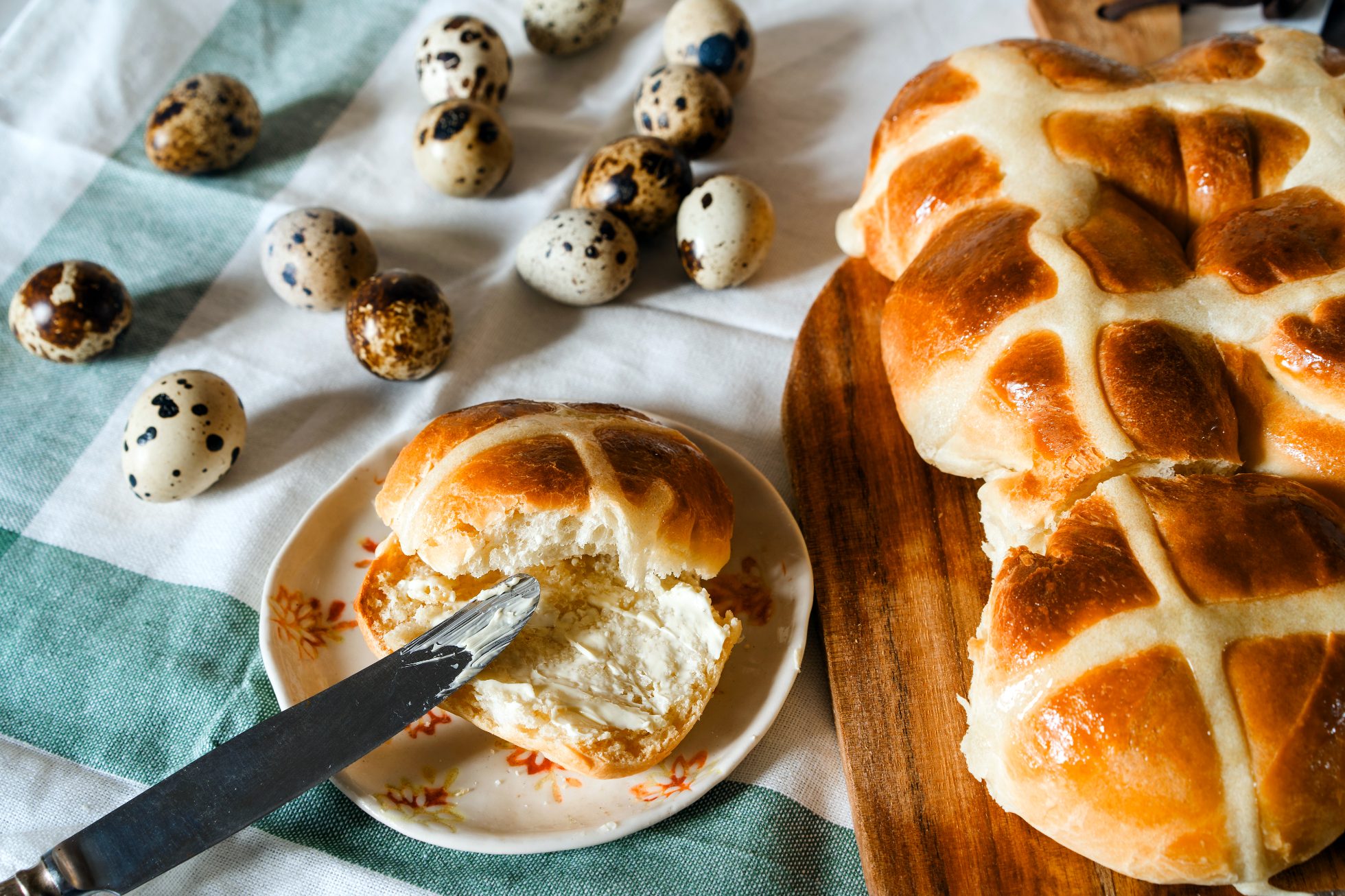 Easter homemade hot cross buns, buttered quail unpainted eggs. Easter idea for family in Canada, Czech Republic, Germany, England; Easter ideas