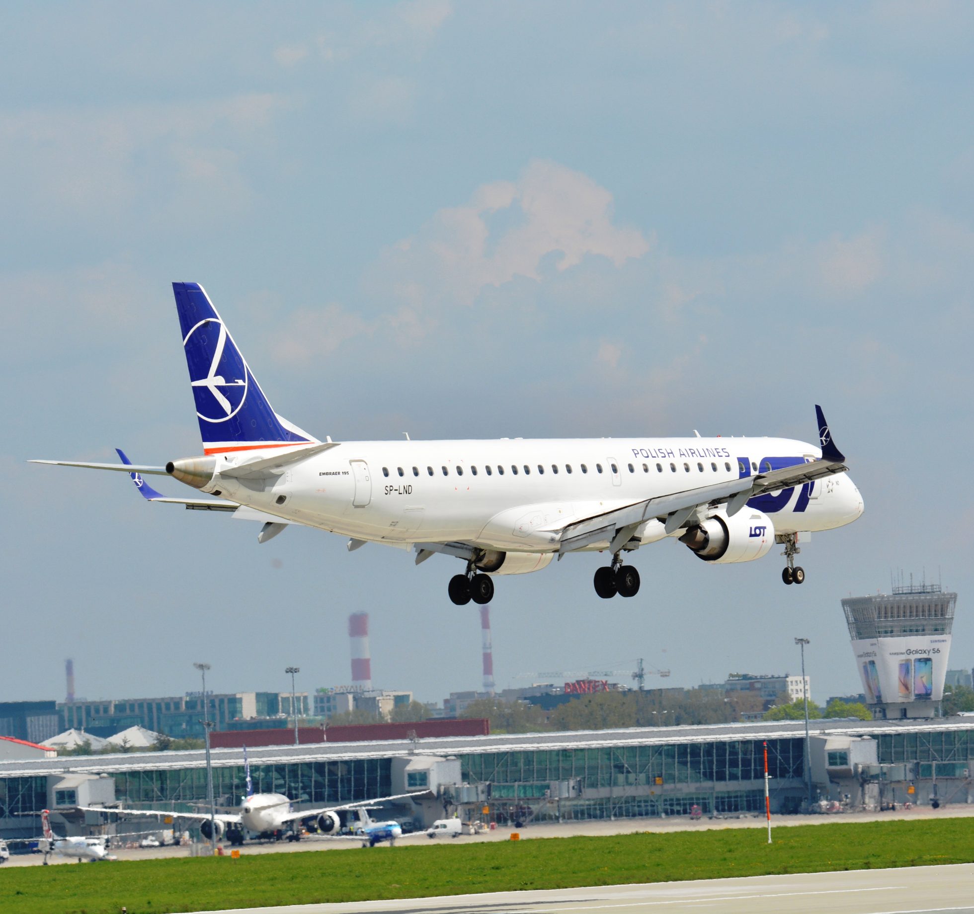 Embraer 195 podchodzący do lądowania w słoneczny dzień