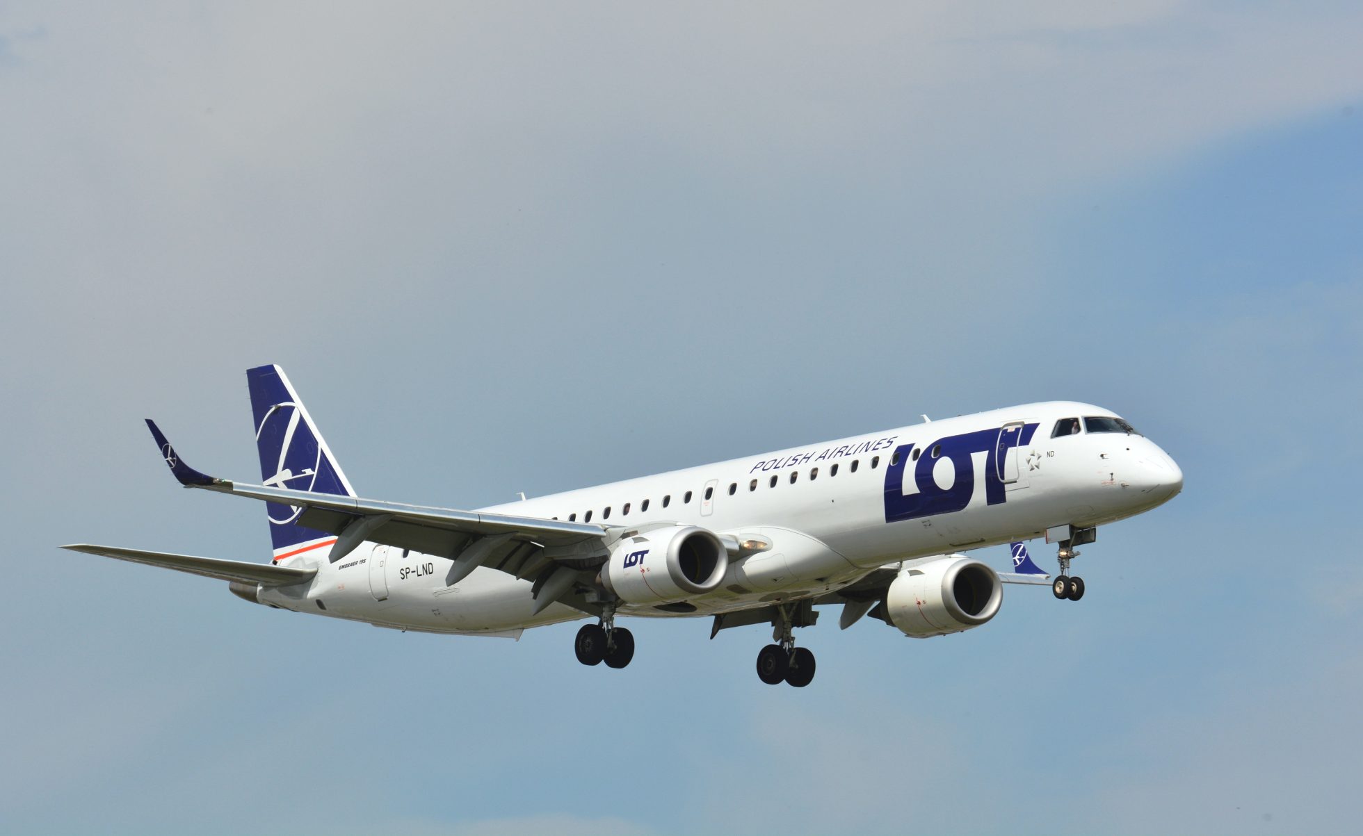 Embraer 195 podchodzący do lądowania na lotnisku Chopina w Warszawie w słoneczny dzień