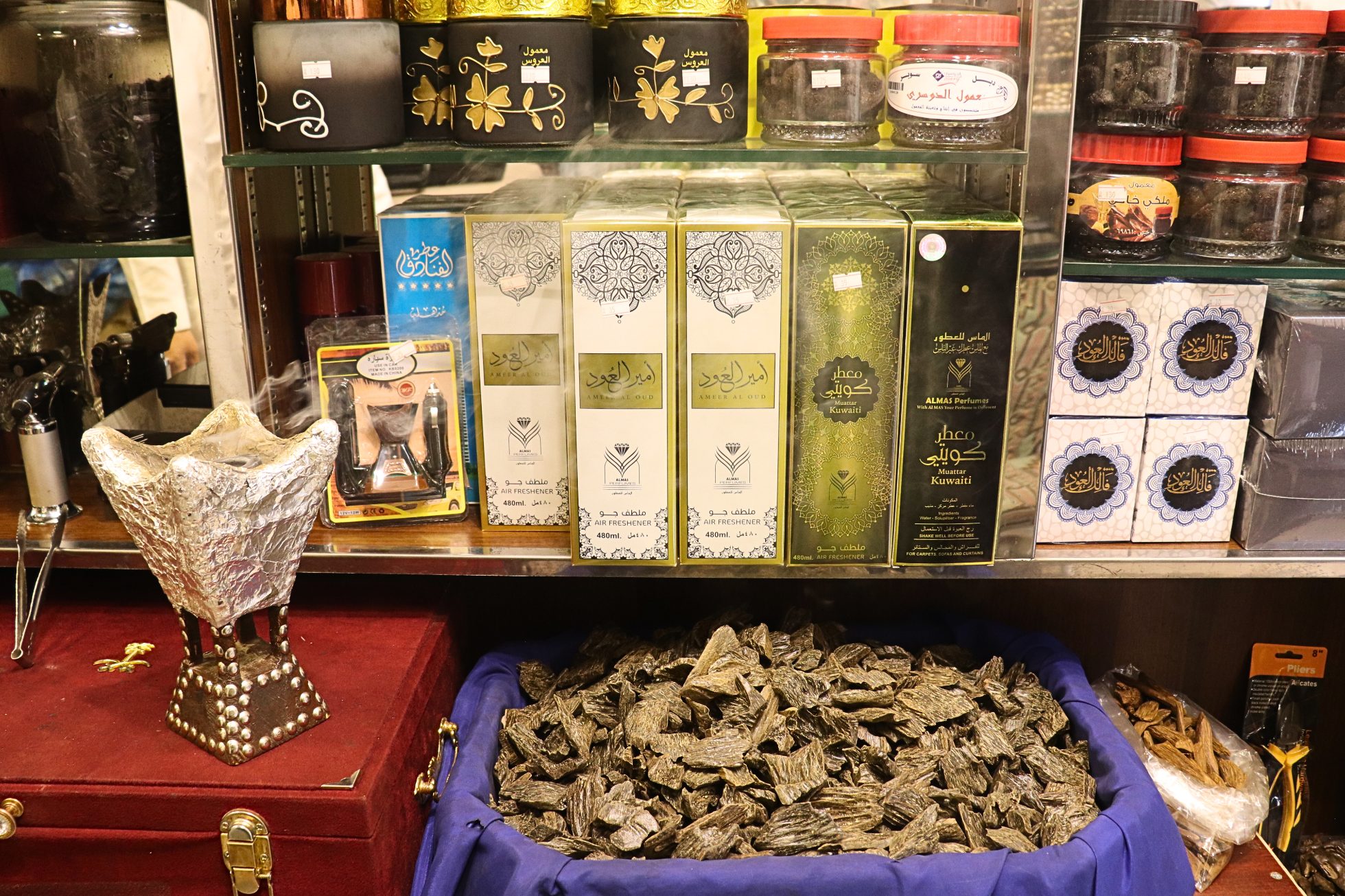 Butelki perfum i kadzidło na drewnianym stole.