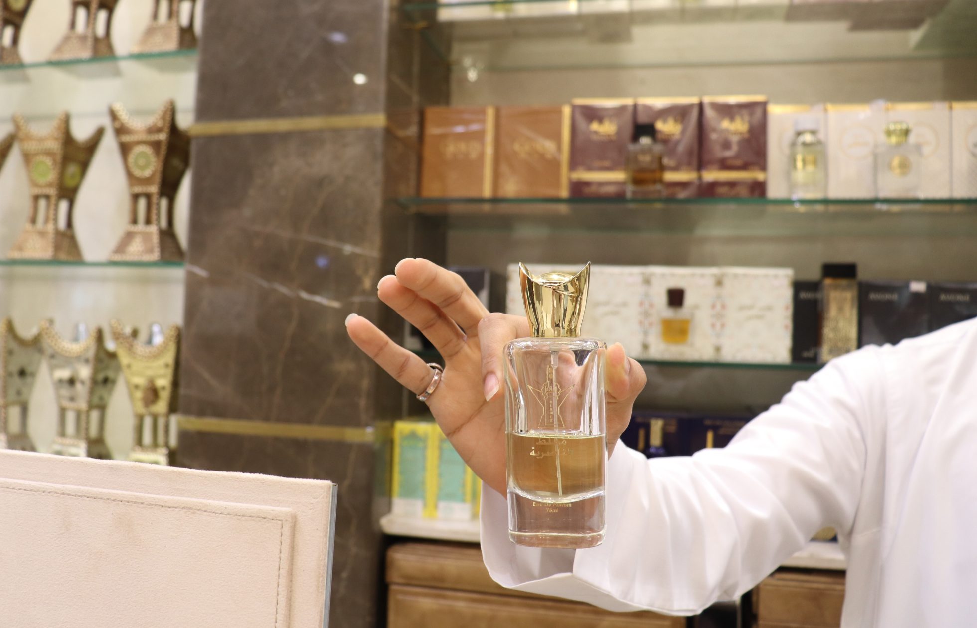 Flakon z perfumami Arabian Wood Oud na tle białego tła.