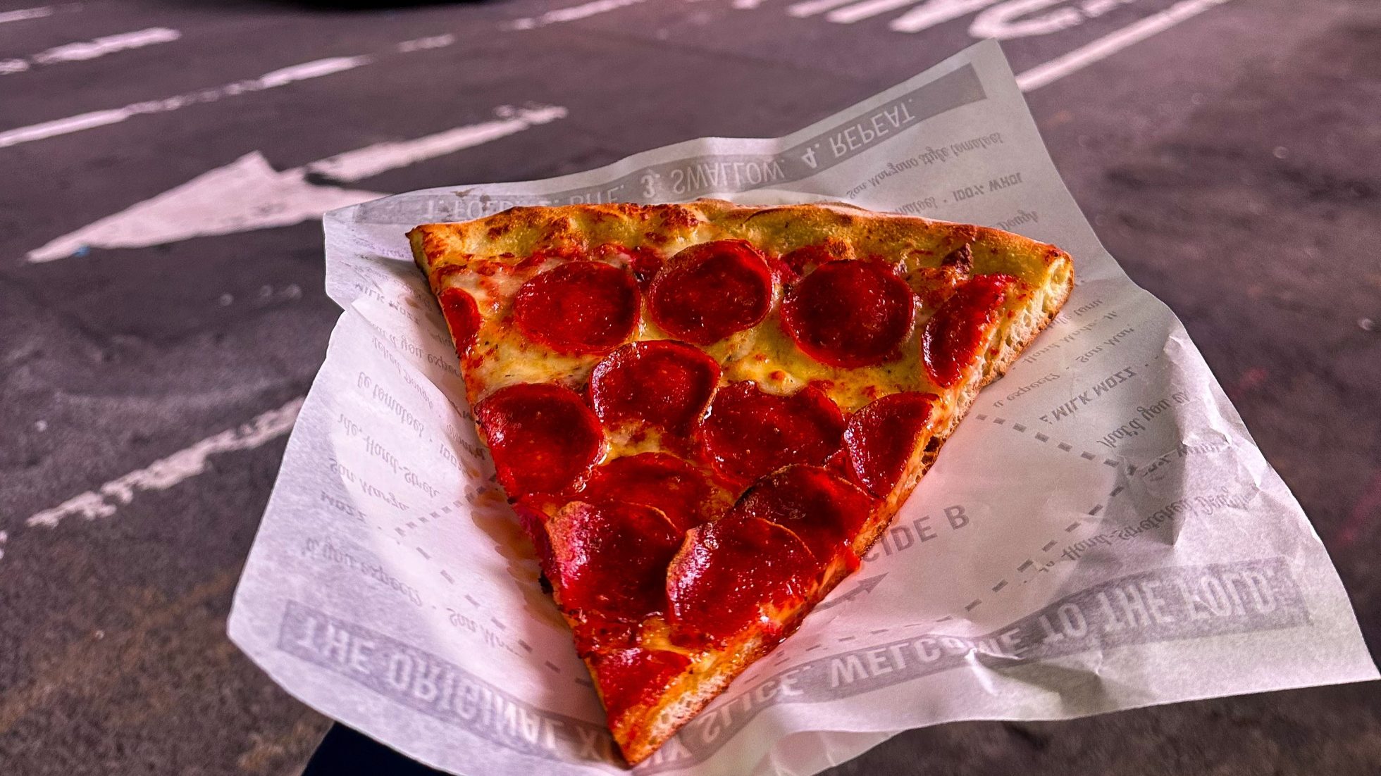 Kawałek pizzy jedzonej na ulicy Nowego Jorku