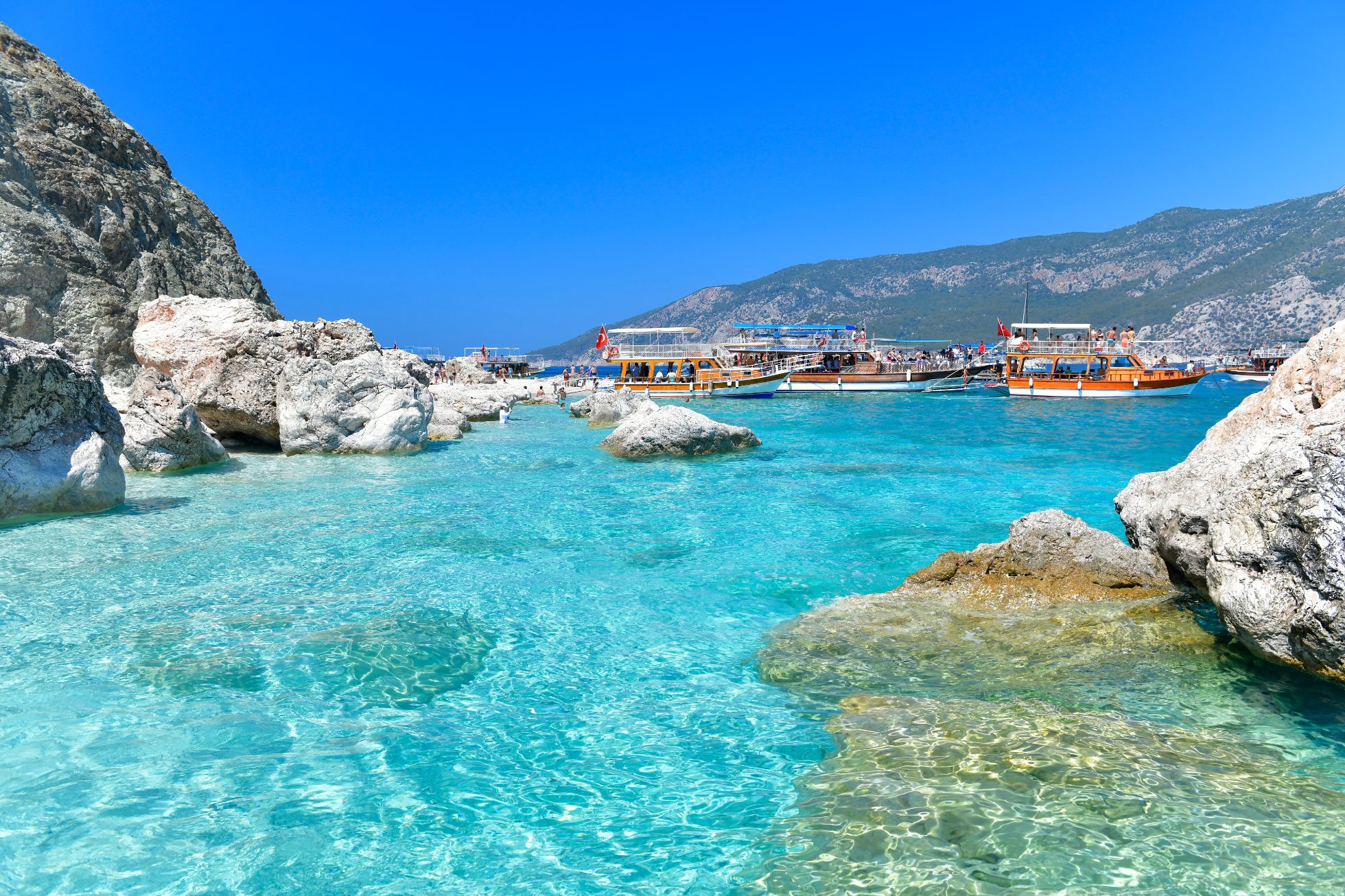 Piękna plaża w Adrasan, Antalya. Błękitne morze, złoty piasek i niebo bez chmur.