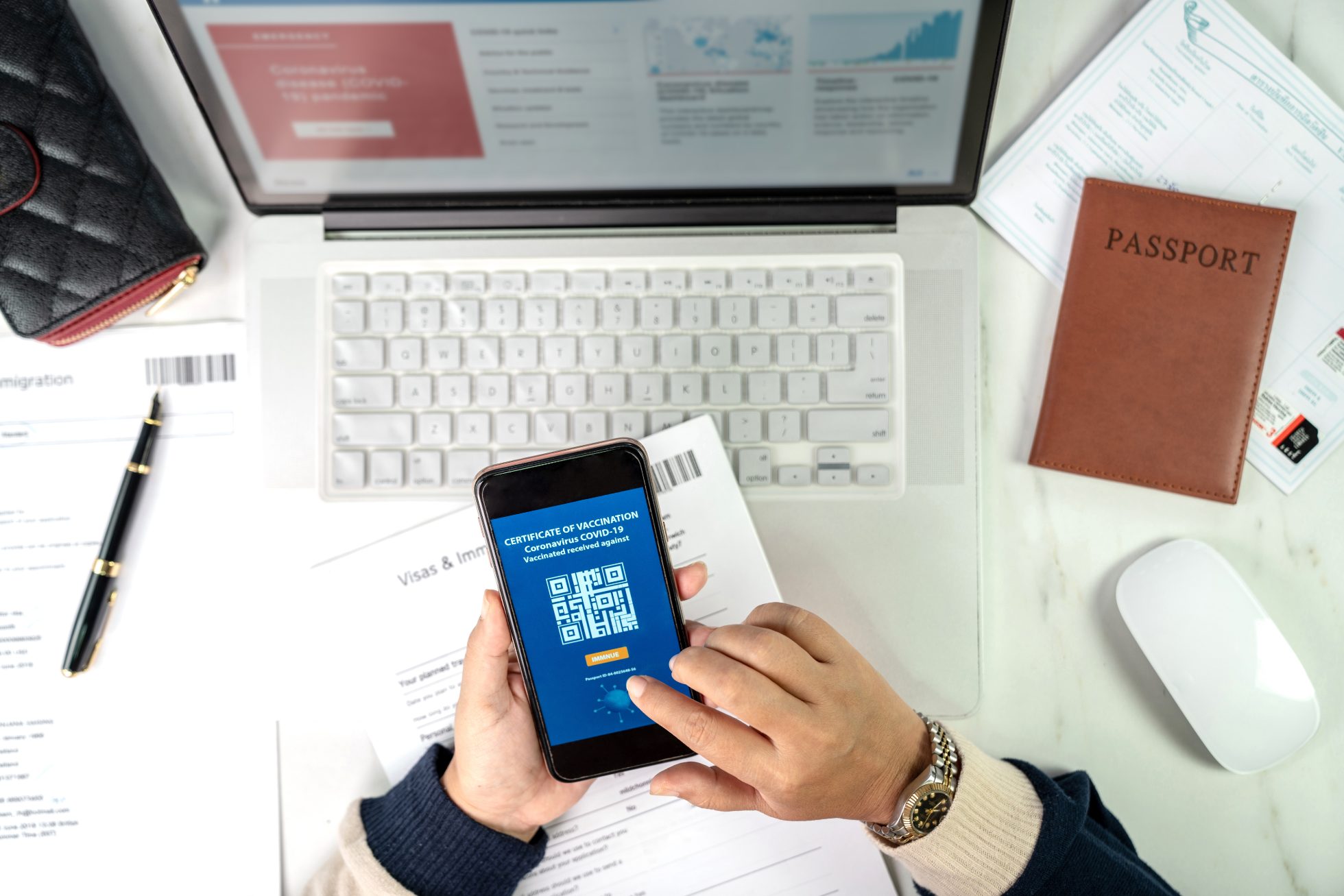 Kobieta dotyka ekranu telefonu komórkowego, sprawdzając status paszportu szczepionkowego w aplikacji