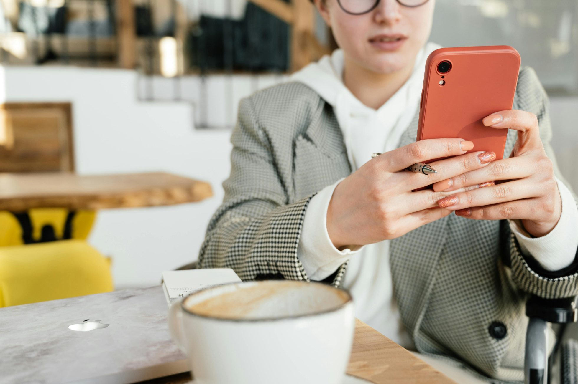 Kobieta ze smartfonem, pracująca w kawiarni