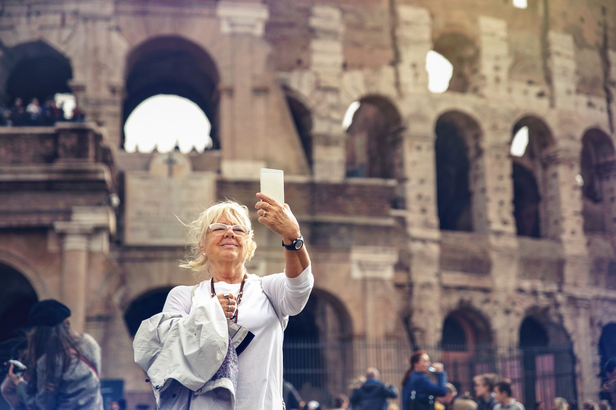Blonde senior woman making a selfie in front of the roman coliseum