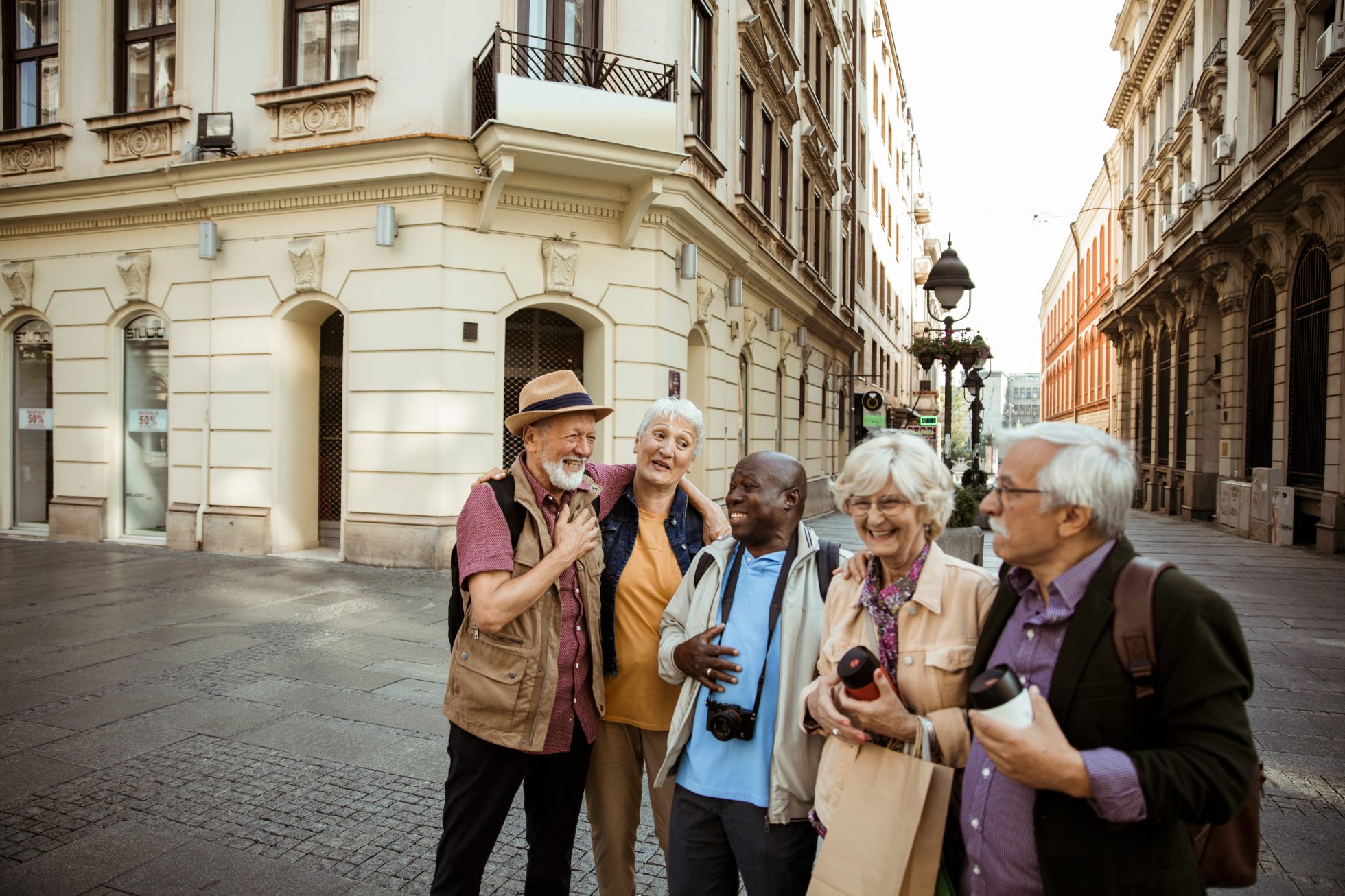 Grupa wesołych seniorów zwiedzająca miasto