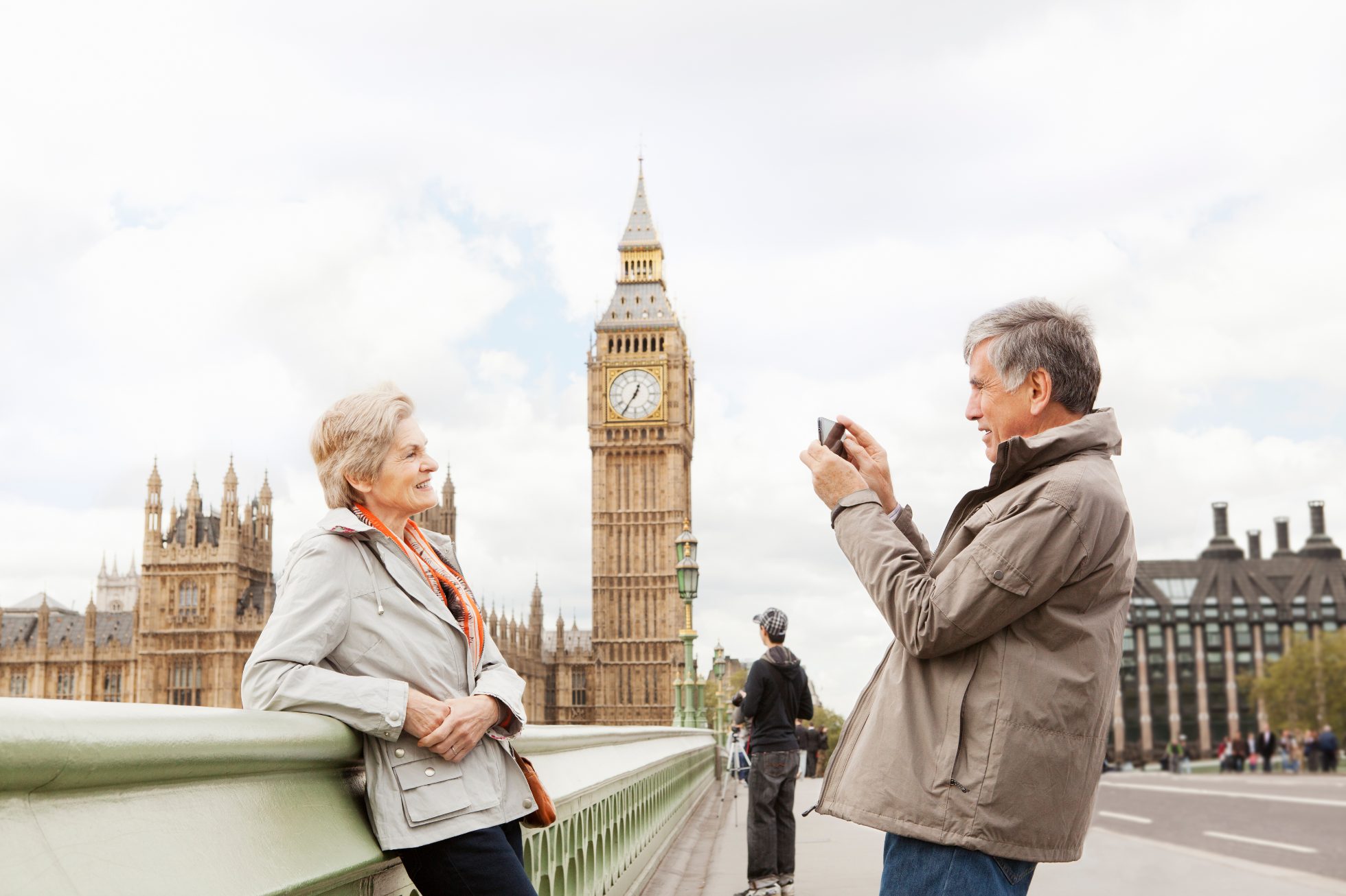 Para seniorów zwiedza Londyn - mąż robi zdjęcia żonie, a w tle Big Ben