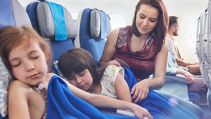 Mama usypia dwie dziewczynki w samolocie