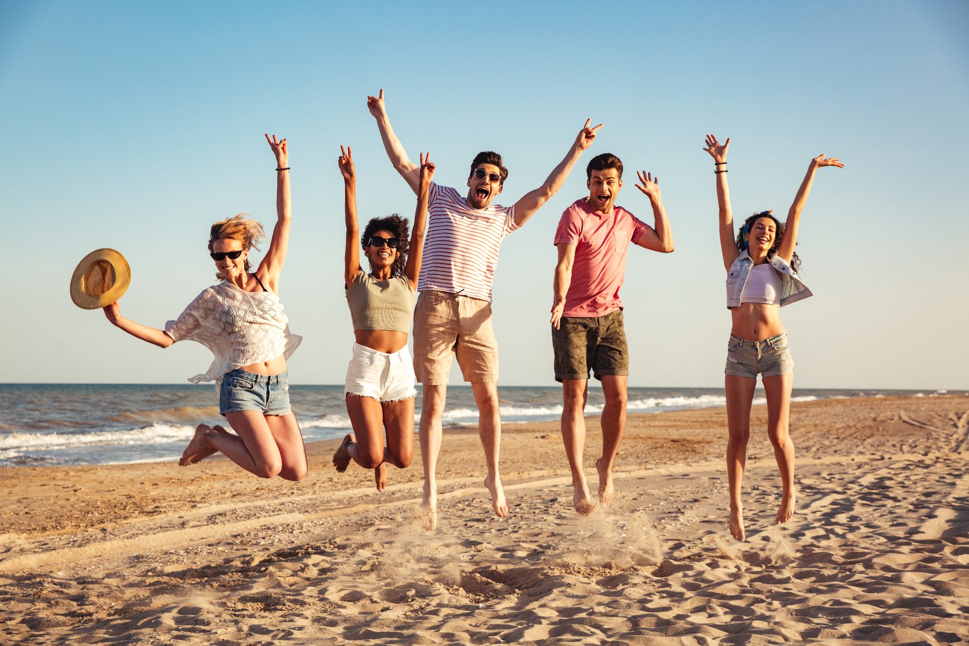 Radośni młodzi ludzie bawią się na plaży