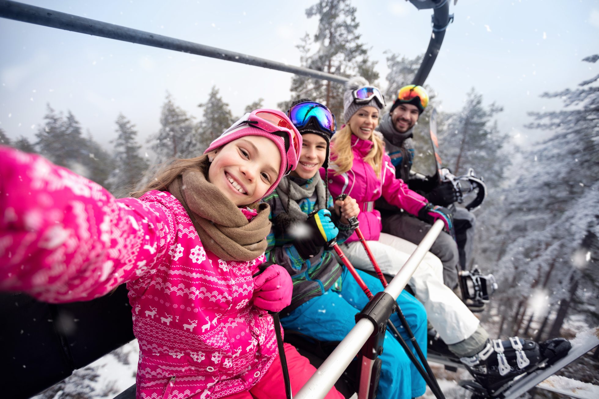 Selfie dziewczyny z rodziną siedzącą na wyciągu krzesełkowym.