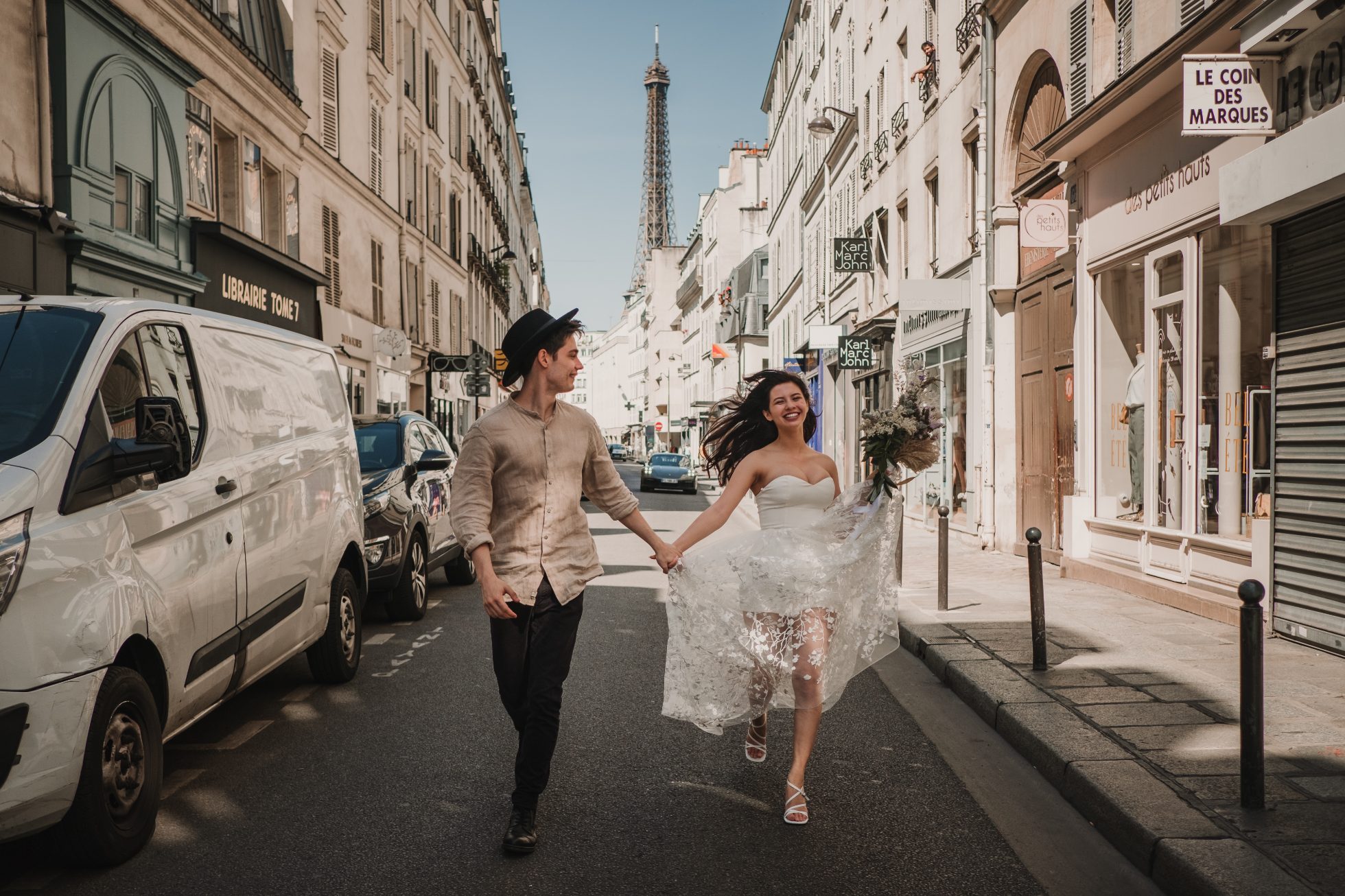 Young couple in elegant clothes stands before ancient buildings in Paris.