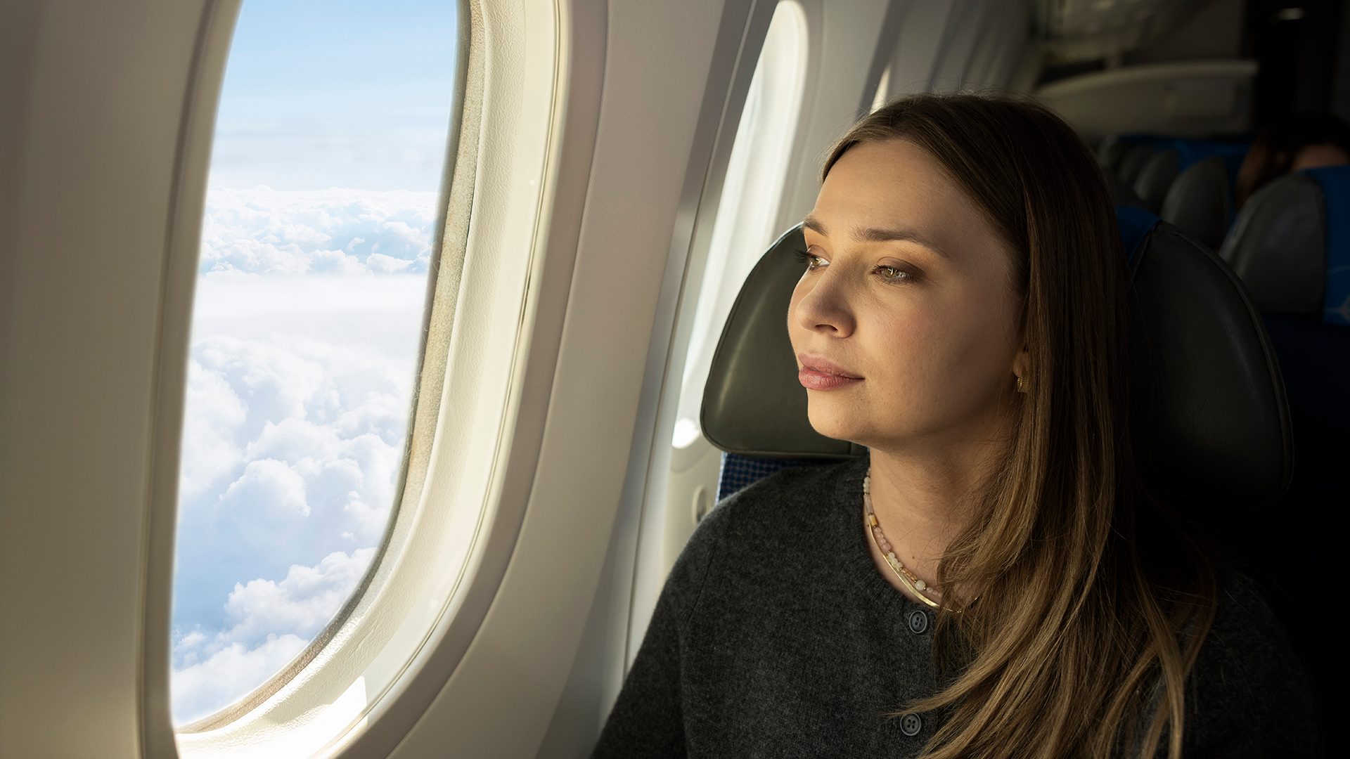Pasażer patrzący przez okno w samolocie Boeing 787 Dreamliner.