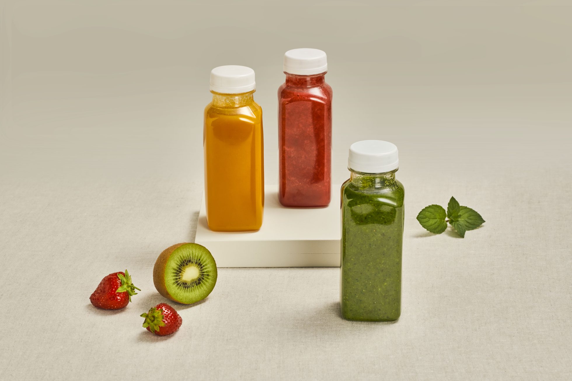 Trzy buteleczki ze smoothie na stole.